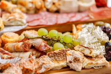 Delicious assortment of appetizers displayed on a wooden platter at a festive gathering