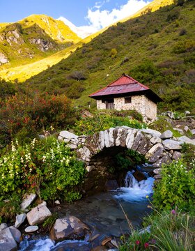 Mountain hut nestled beside a babbling brook