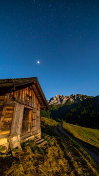 Mountain hut under a starry night sky