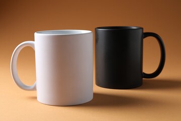 Promotion. White and black mugs on brown background