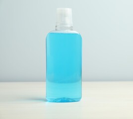 Bottle of mouthwash on white wooden table. Oral hygiene