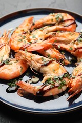 Tasty grilled shrimps with sauce on black table, closeup. Delicious seafood dish