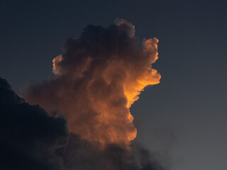 form of a dog , Dramatic cloudscape at sunset with sunlight and dark blue sky