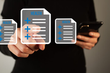 Businesswoman holding a cell phone and selecting a document with health forms
