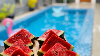 Obraz na płótnie Canvas red water melon with swimming pool view 