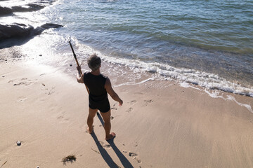 海でSUPを楽しむ日本人シニア男性
