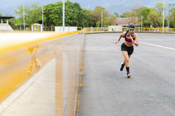 Woman running with intensity on outdoor running track, 43-year-old senior Latina showing energy and...