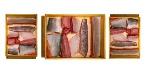 Top view of assorted fresh raw fish fillets in a wooden box.