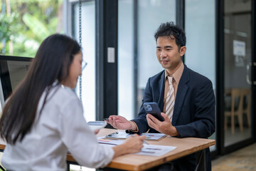 Business people discussing work using mobile phone and documents