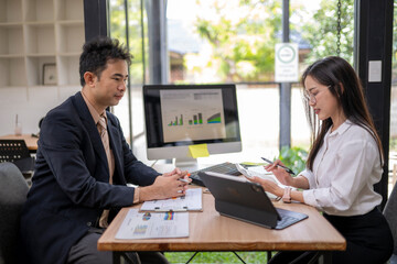 Business people analyzing charts and discussing financial strategy in office meeting