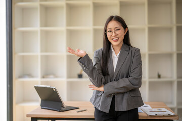 Smiling businesswoman gesturing with hand in modern office