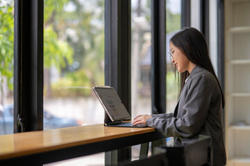 Businesswoman working on tablet with charts and graphs in modern office