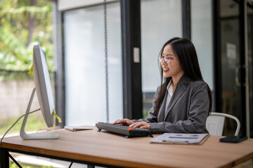 Young asian businesswoman working on computer in modern office