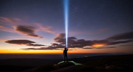 Lone figure reaches towards a powerful beam of light against a dramatic sunset sky