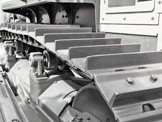 Detailed view of construction machine track components showing gears and rollers for enhanced performance