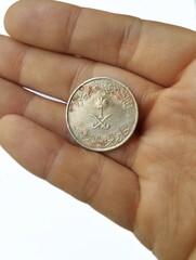Hand holding a Saudi Arabia coin