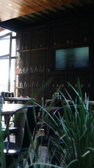 Terraza con mesas metálicas junto a gran árbol