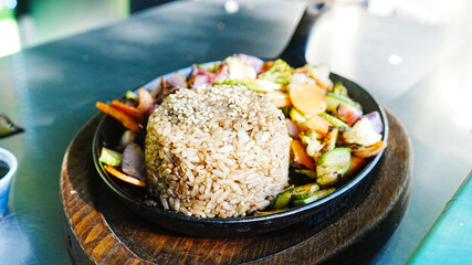 Arroz con vegetales salteados en sartén negro