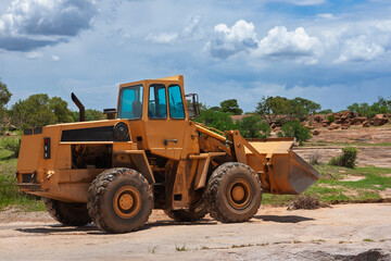bucketloader, bucket loader construction machinery driving on dirt road to the construction site, african landscape