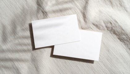 Two Blank White Business Cards Mockup on Textured Bone Linen Surface with Crisp Sunlight and Shadows
