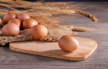 Fresh organic eggs from the farm are placed on a wooden table in the kitchen for preparing breakfast. Healthy food.