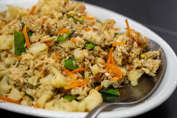 Delicious Fried Rice with Vegetables and Chicken Served on a White Plate with a Spoon