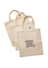 Three canvas bags with reduce reuse recycle message and a leaf icon on a plain surface view