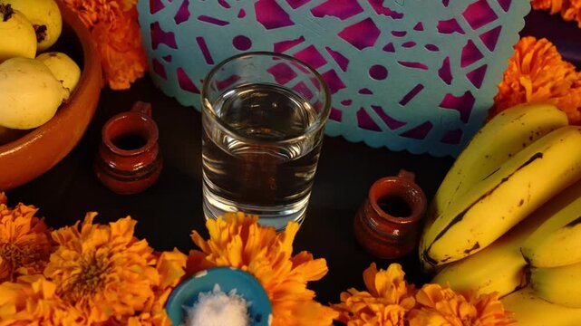 Offerings for the Day of the Dead, a Hispanic celebration in Mexico, decorated with marigold flowers, fruit, water, and papel picado