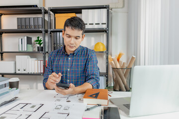A young architect works on house design plans at his desk, focusing on drawings and scale models. The scene conveys creativity, dedication, and precision in modern architecture projects.