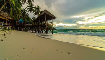 Golden Hour on a Tropical Beach with a Pathway to Water Villas