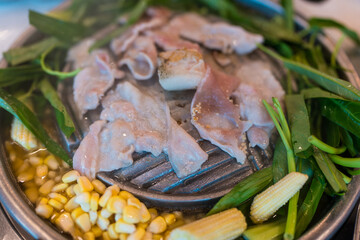 Thai Barbecue called Mookata, you can picking up a piece of sliced pork on the pan and put some vegetables into soup.