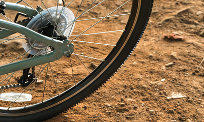 Naklejka premium Close-up of a Mountain Bike Rear Wheel on a Dirt Trail
