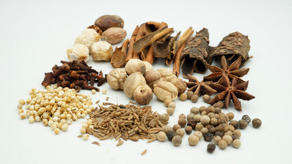 A vibrant array of spices, such as cloves, cinnamon, and nutmeg, are laid out, highlighting...