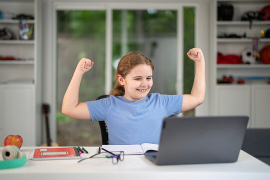 Kid learning at home with laptop and books. Child learn online using laptop at desk. Learning with homework in child room. E-learning on laptop. Kid learning at home. Back to school.