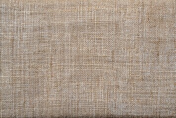 Beige fabric with a woven texture, showing detailed threads in a close-up view, creating a rustic, natural feel