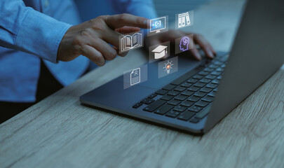 Close-up of professional hand operating laptop with education and e-learning icons, symbolizing online study, artificial intelligence digital training, and knowledge technology.