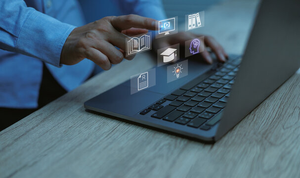 Close-up of professional hand operating laptop with education and e-learning icons, symbolizing online study, artificial intelligence digital training, and knowledge technology.