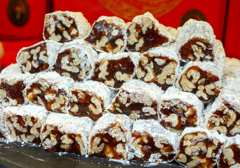 Slices of a traditional nut filled dessert roll likely Turkish delight or cezerye are arranged in a cascading stack highlighting the rich texture and nutty ingredients