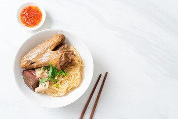 dried noodles with braised duck in white bowl