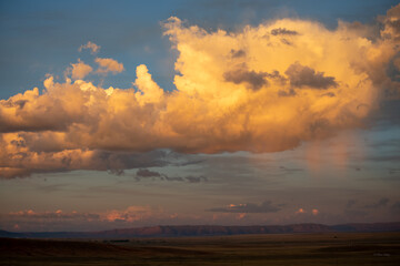 Goldn yellow sunset clouds on blue sky in Wyoming