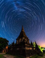 Ancient temple under a starlit sky with star trails