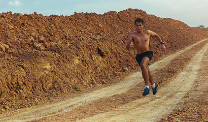 Young man runner running trail. sprinting at rural dirt path. Healthy and lifestyle concept
