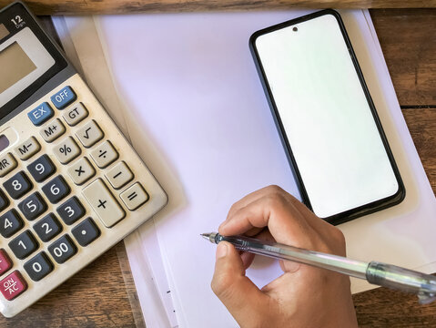 Hand writing on paper with calculator and blank smartphone screen for finance and education concept - Powered by Adobe