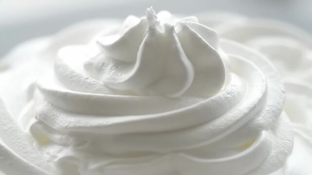 Swirling Whipped Cream Close-Up - A detailed close-up shot of a swirl of whipped cream, showcasing its texture and smooth, creamy peaks.