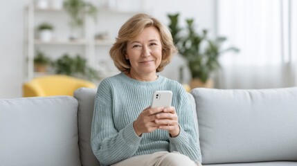 Happy middle-aged woman using smartphone on couch in cozy living room with houseplants and bright natural lighting, enjoying digital connectivity and leisure time
