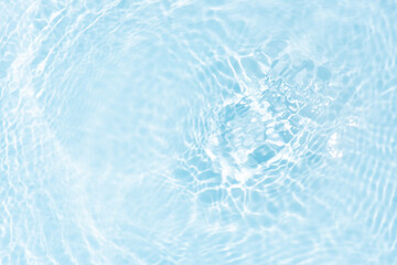 Blue water with ripples on the surface. Defocus blurred transparent blue colored clear calm water surface texture with splashes and bubbles. Water waves with shining pattern texture background.