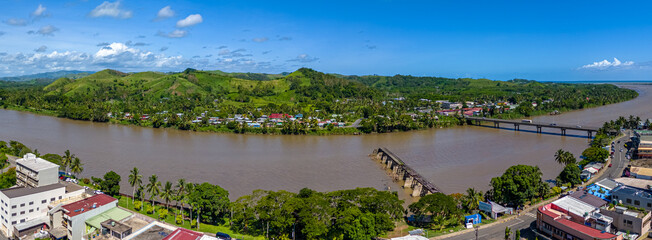 Stunning aerial panorama of Sigatoka, Fiji, located on a large bend of the river. Shows the town,...