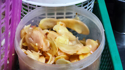 Sliced pickled ginger in plastic container