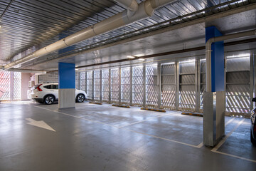 Indoor covered car park featuring marked parking bays, structural columns, and clear directional...
