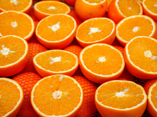 A vibrant background of freshly sliced oranges arranged in a crate showcasing their juicy texture and bright color a symbol of health and vitamins